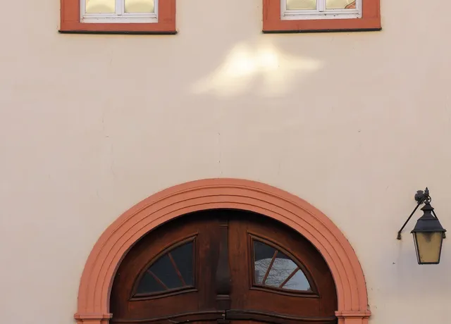 Hauseingang mit Rundbogentür und Wandleuchte