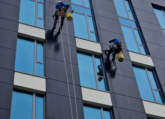 Zwei Fassadenreiniger im Seilzugang an einem Hochhaus