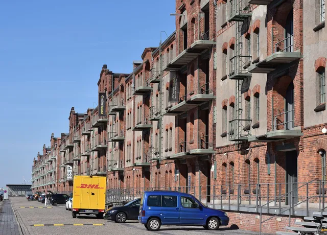 Backsteingebäude mit Hoffläche und Lieferfahrzeug