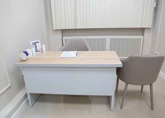 Sprechzimmer mit Schreibtisch und Besucherstuhl
