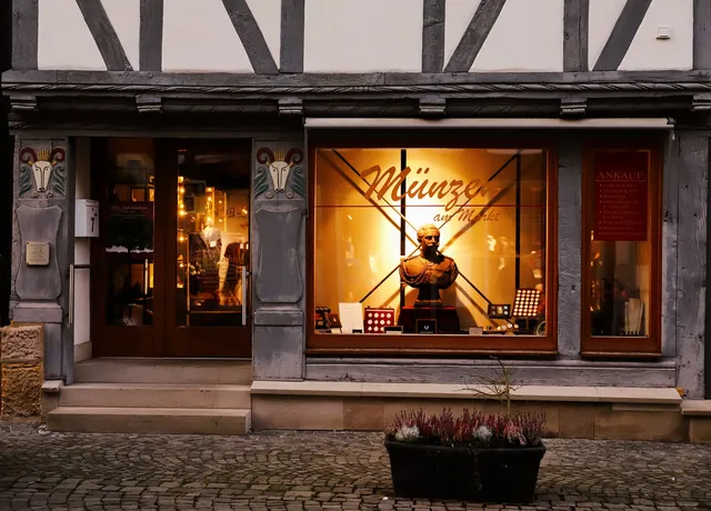 Ladenfront mit beleuchtetem Schaufenster am Abend