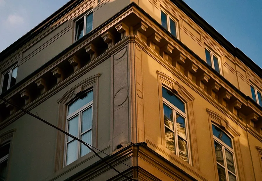 Verputzte Altbaufassade mit Gesimsen und Fenstern
