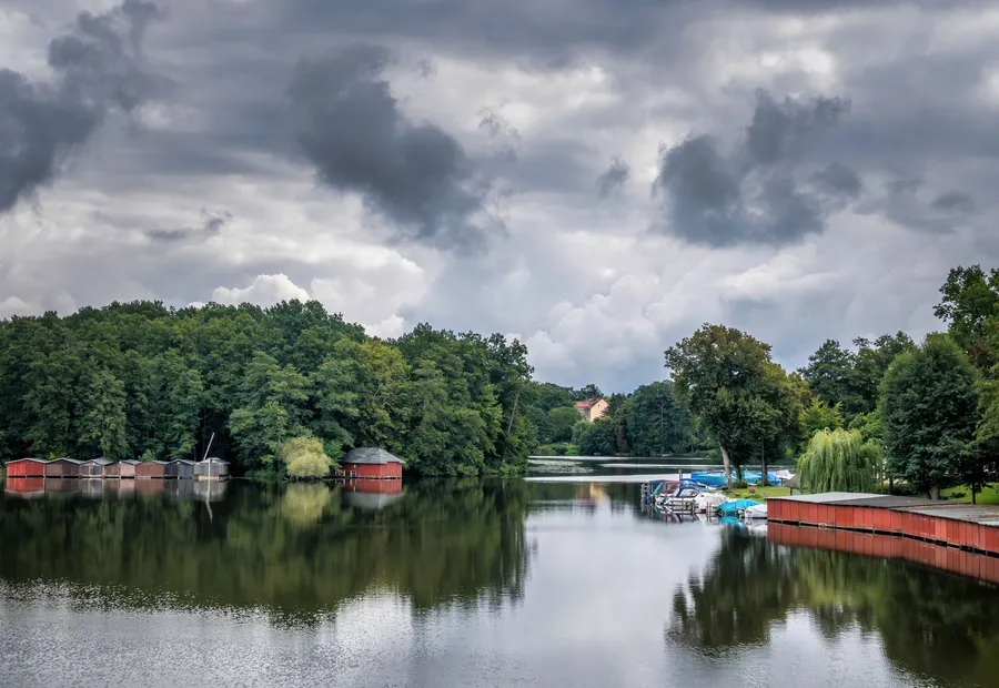 Flusslauf mit Uferpromenade und Baumbestand