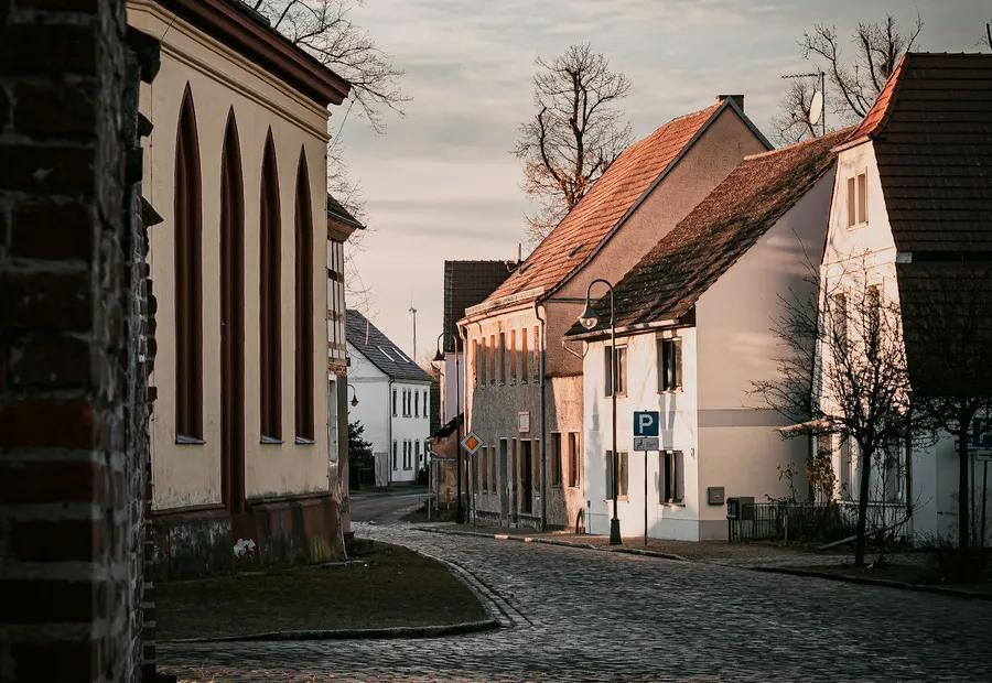 Dorfstraße mit Kirche und verputzten Wohnhäusern