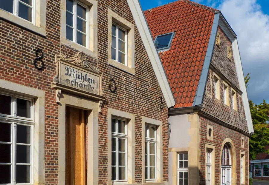 Backsteinhaus mit Hinweisschild an der Straße